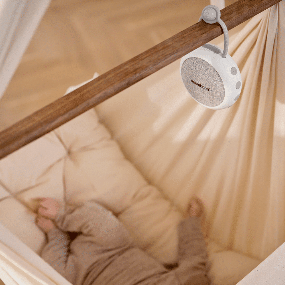 En högtalare för white noise från Moonboon som hänger i en hängvagga, så att barnet kan somna till white noise-ljuden från högtalaren