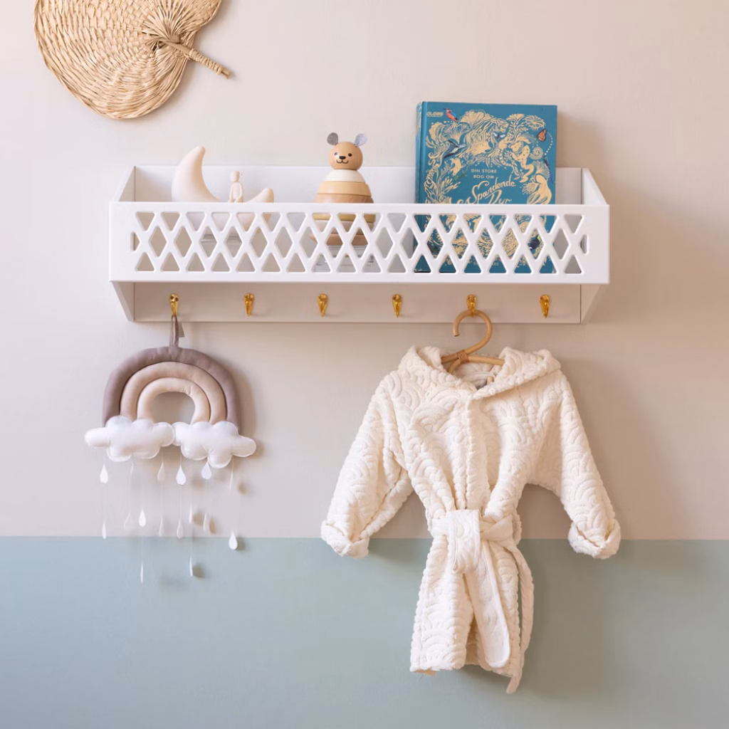 a shelf with toys and a white robe on a wall. cam cam Harlequin Hylde med knager, FSC Mix - Hvid